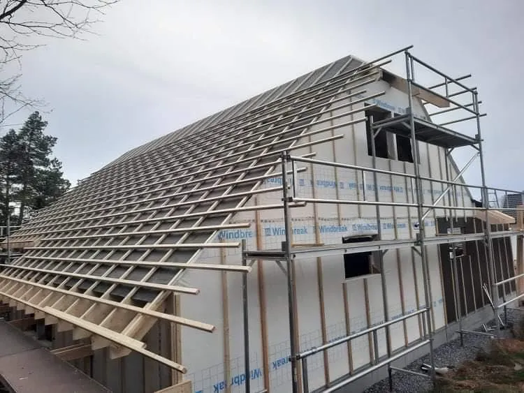 Stillas langs hus med nytt takverk