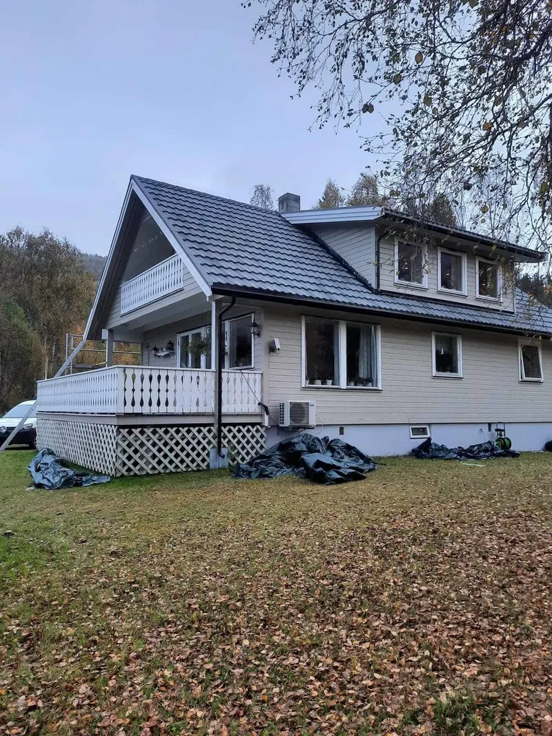 Hvit bolig med trapp ved inngangspartiet